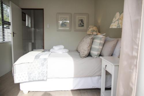 a bedroom with a white bed with pillows on it at Olive Manor Guest House in Newcastle