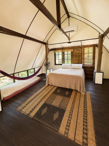 a bedroom in a tent with a bed and a rug at The Secret Sanctuary in Kuching
