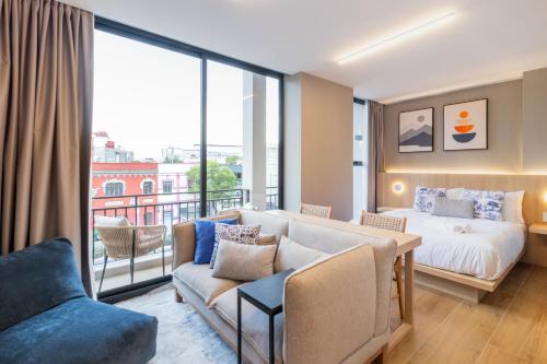 a hotel room with a bed and a couch at Myla Magnolia in Mexico City