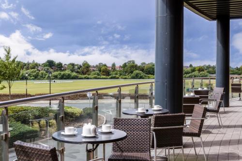 a patio with tables and chairs and a view of a baseball field at ABode Chester in Chester