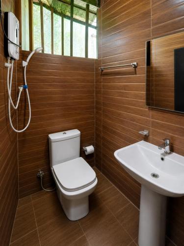 a bathroom with a toilet and a sink at Tree House Cabana Sigiriya in Sigiriya