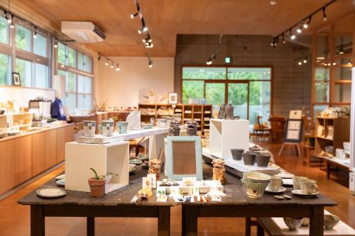 a large room with a table with pottery on it at Bunagaya in Ujimi