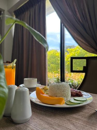 a plate of food on a table with a window at Villa Verde Guest House in General Santos