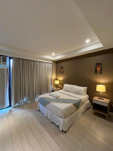a large bedroom with a large bed and two lamps at Villa Verde Guest House in General Santos
