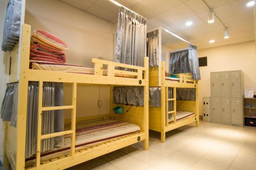 a room with two bunk beds in a room at Little House in Chiayi City