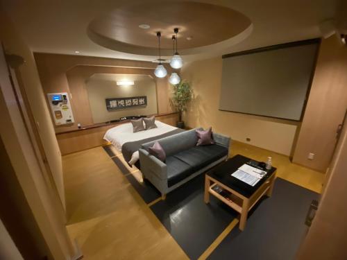 a living room with a couch and a screen at ホテル大東京 男塾ホテルグループ Adult Only in Takamatsu