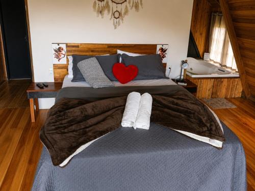 a bed with two towels and a red heart on it at Pé na Picada in Urubici