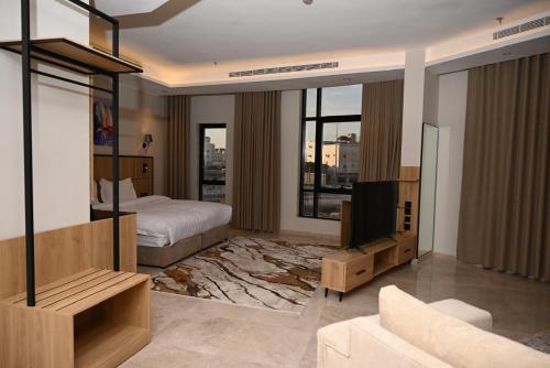 a bedroom with a bed and a tv and a couch at فندق أونارا ستاي in Medina