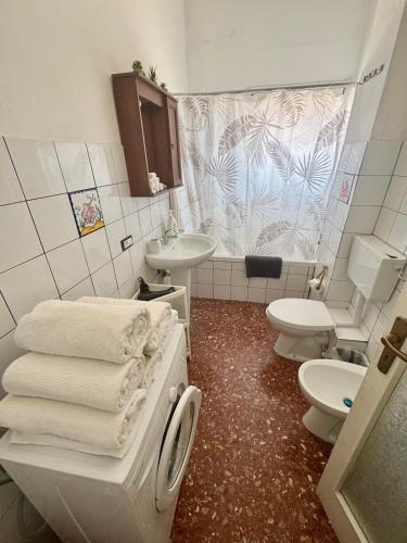 a bathroom with two toilets and a sink and towels at Penthouse Panoramic in Pantelleria