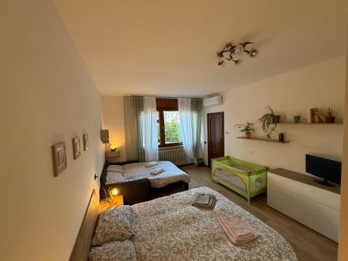 a hotel room with two beds and a television at Ai Melograni Apartment in Silea