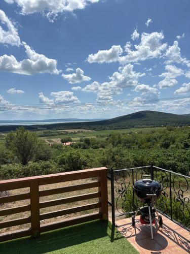 a grill on a balcony with a view of the mountains at Mona-Lak Balaton Panorama in Zánka