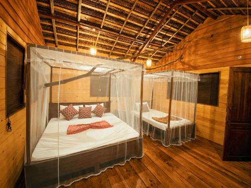 a bedroom with two beds in a wooden room at Tree House Cabana Sigiriya in Sigiriya