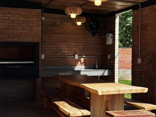 a outdoor kitchen with a wooden table and benches at Departamento cerca a Asunción 412 in Luque