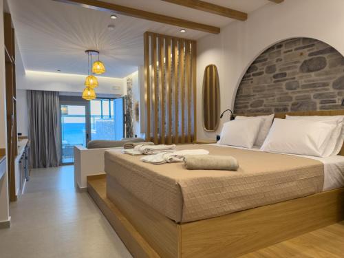 a bedroom with a large bed with a stone headboard at Marizon Suites - Adults Only in Vrachonisída touArchangélou