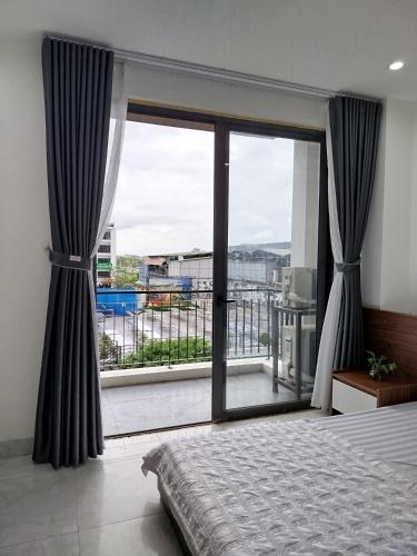 a bedroom with a large window with a view at KHÁCH SẠN R Hotel in Sầm Sơn