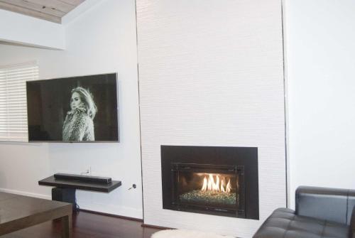 a living room with a fireplace with a picture of a woman at Silicon Valley Stays Casa Uno in Mountain View