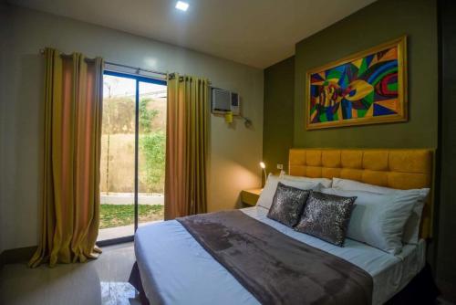 a bedroom with a large bed and a window at ETT HomeTel in Kalibo