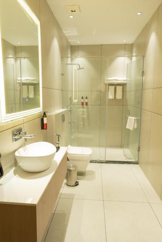 a bathroom with two sinks and a glass shower at Ramee ColleXtion Amritsar, Near Golden Temple in Amritsar