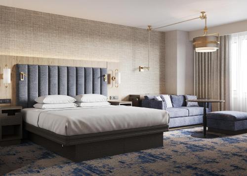 a bedroom with a bed and a couch and a chair at Hyatt Regency Jersey City on the Hudson in Jersey City