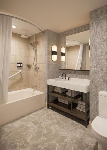 a bathroom with a tub and a sink and a toilet at Hyatt Regency Jersey City on the Hudson in Jersey City