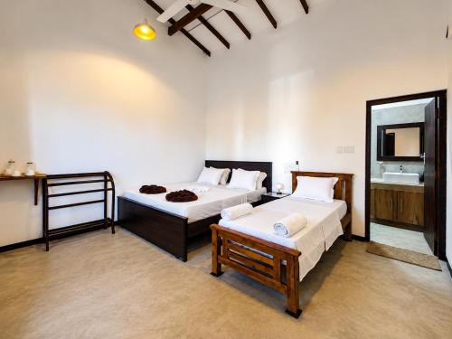 a hotel room with two beds and a mirror at Jesoloresort Arugambay in Arugam Bay