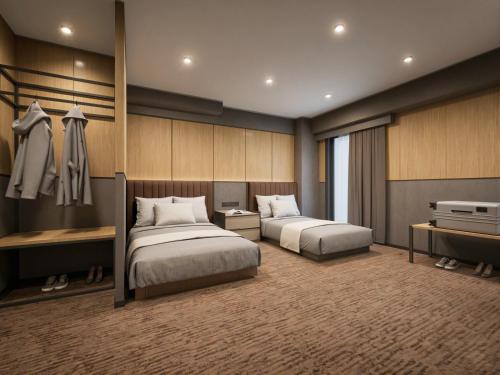 a bedroom with two beds and a tv in it at KABIN Shiro - Regale Collection in Osaka