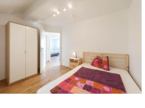 a white bedroom with a bed and a closet at Ferienwohnung Rohrhofer in Tiefenbach