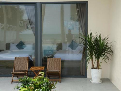 two chairs and a table in front of a bedroom at 86 Villa in Mui Ne