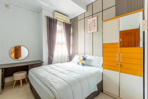 a bedroom with a bed and a desk and a mirror at Homestay Rumahnya Diaz in Kejayan