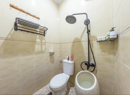a bathroom with a toilet and a shower at Homestay Rumahnya Diaz in Kejayan