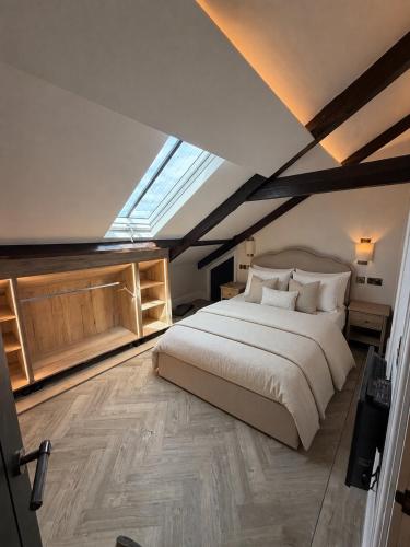 a bedroom with a large bed and a skylight at Oat & Olive Apartments - Alnwick in Alnwick