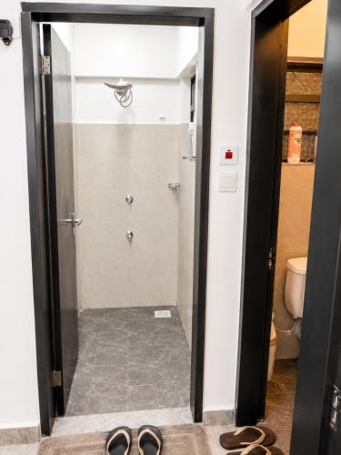 a door to a shower with a pair of shoes at Calvin's corner in Kisumu