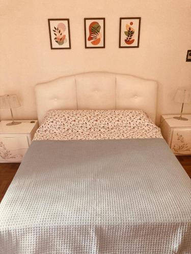 a bed in a bedroom with three pictures on the wall at Lungomare Crotone in Crotone