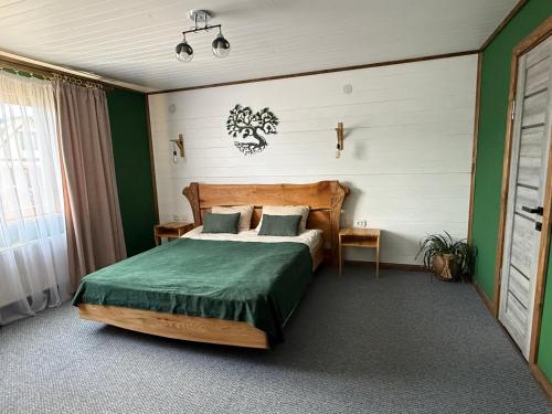 a bedroom with a bed with a green comforter at fazenda slavsko in Slavske