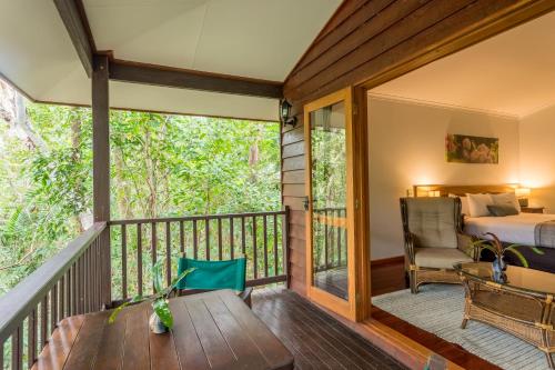 a room with a balcony with a bedroom and a bed at Thala Beach Nature Reserve in Port Douglas