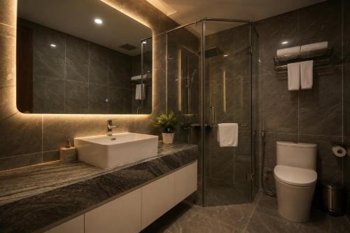 a bathroom with a sink and a toilet and a shower at H-Vista WestGate Suites in Hanoi