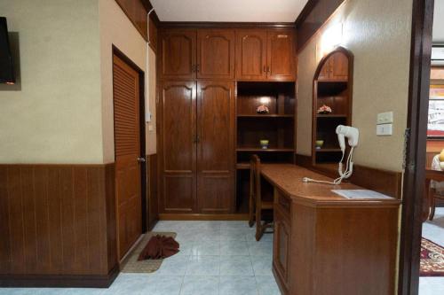 a room with a desk and wooden cabinets at Banna Resort in Ban Khlong Kadon (1)