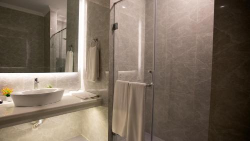a bathroom with a sink and a shower at Alhamra Hotel in Mardan