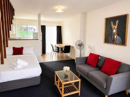 a hotel room with a bed and a couch at Midway Pacifica Lodge in Lower Hutt