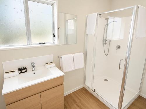 a bathroom with a shower and a sink at Midway Pacifica Lodge in Lower Hutt