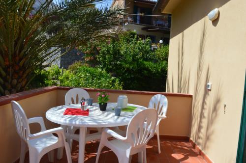 Casa Vacanza La Zanca في Zanca: طاولة بيضاء وكراسي على شرفة