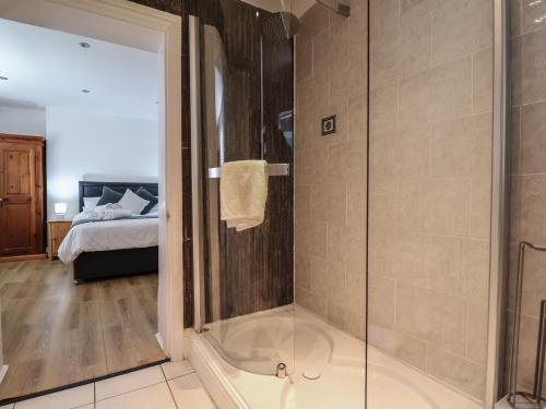 a bathroom with a shower with a glass door at 4 Green Farm Cottage in Chester