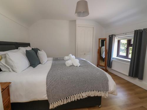 a bedroom with a bed with a stuffed animal on it at 4 Green Farm Cottage in Chester