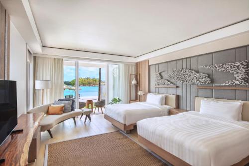 a hotel room with two beds and a television at Shangri-La Le Touessrok, Mauritius in Trou d'Eau Douce