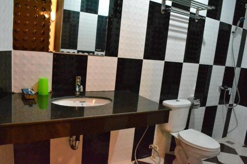 a bathroom with a sink and a toilet at Capital Battambang Hotel in Battambang