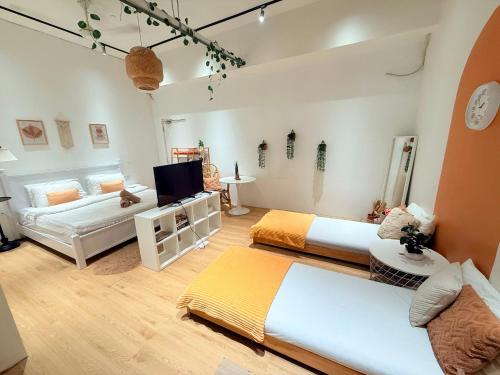 a room with two beds and a tv and a couch at Helena’s Studio Suite Gerik in Gerik