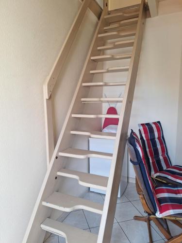 a wooden staircase in a room with a chair at Petite maison proche cathédrale hyper centre in Toul