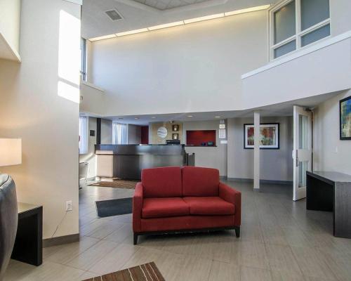 a waiting room with a red chair in a lobby at Comfort Inn Regina East in Regina