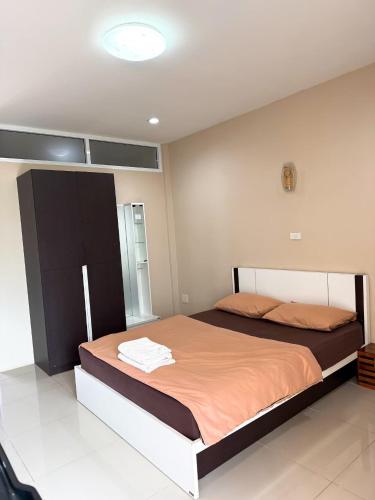 a bedroom with a large bed with orange sheets at Ratchanee Place in Chaiyaphum