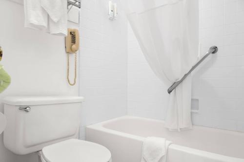 a bathroom with a white toilet and a phone at Quality Inn Rock Springs - Green River in Rock Springs